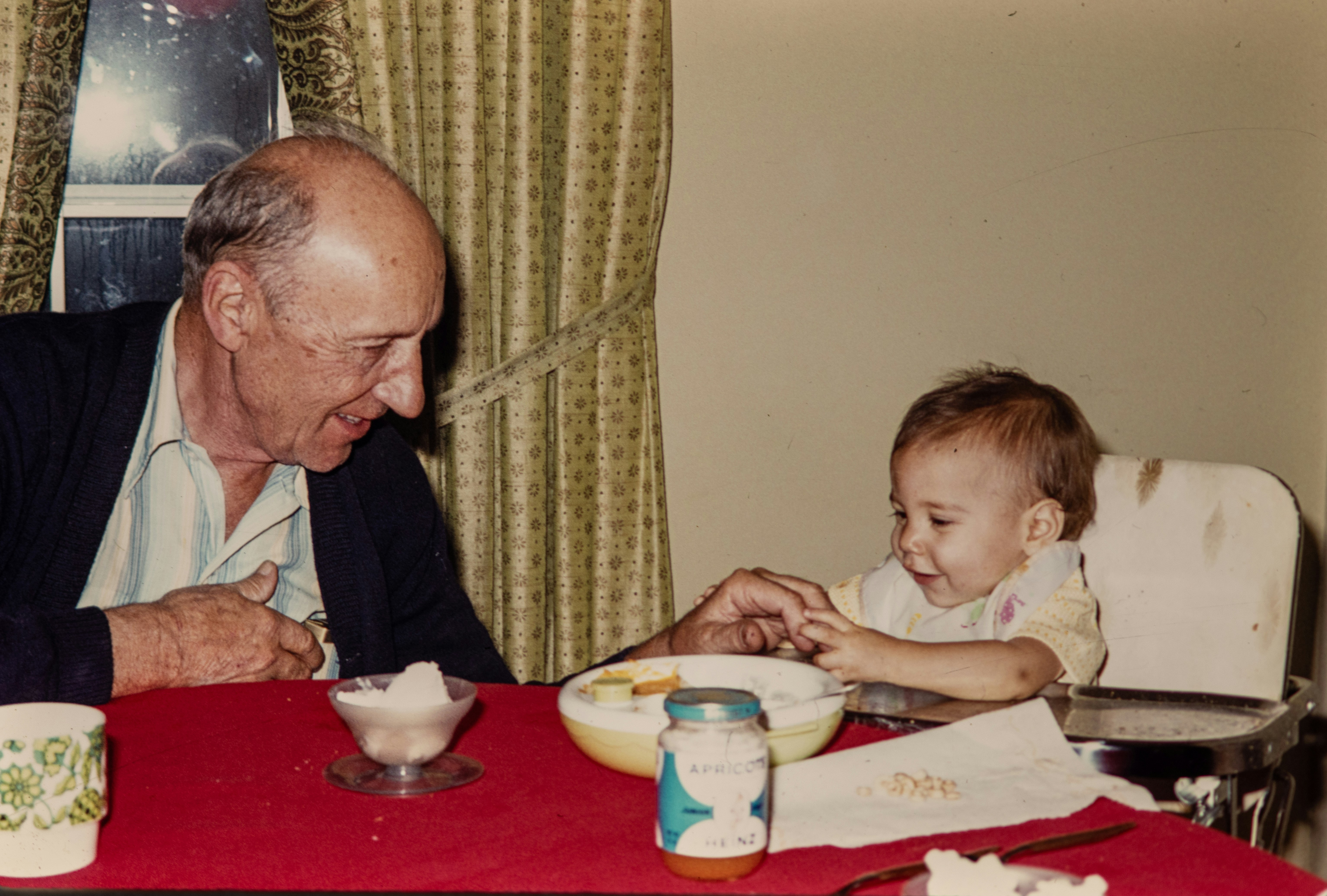 A grandparent and child sitting at the dining table sharing a quiet moment.