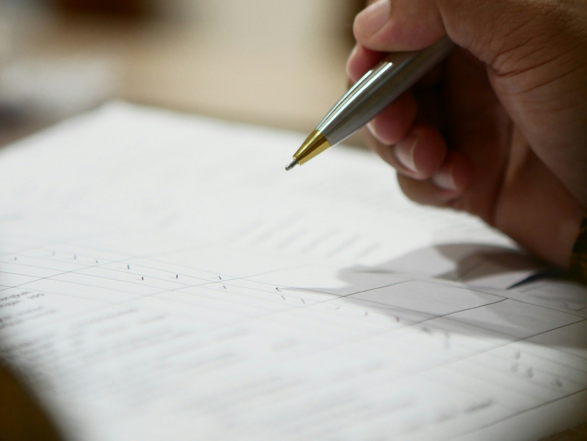 A hand signing a legal document with a pen.