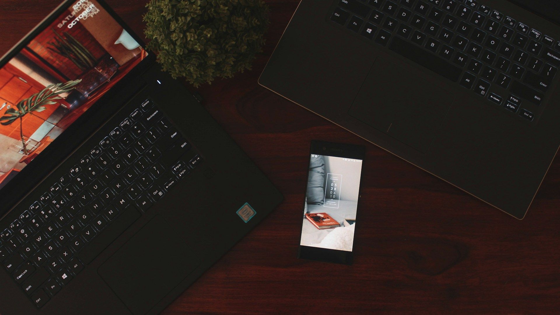 A laptop and an iPhone side-by-side on a desk, mid-transfer, representing migrating data from one app to another.