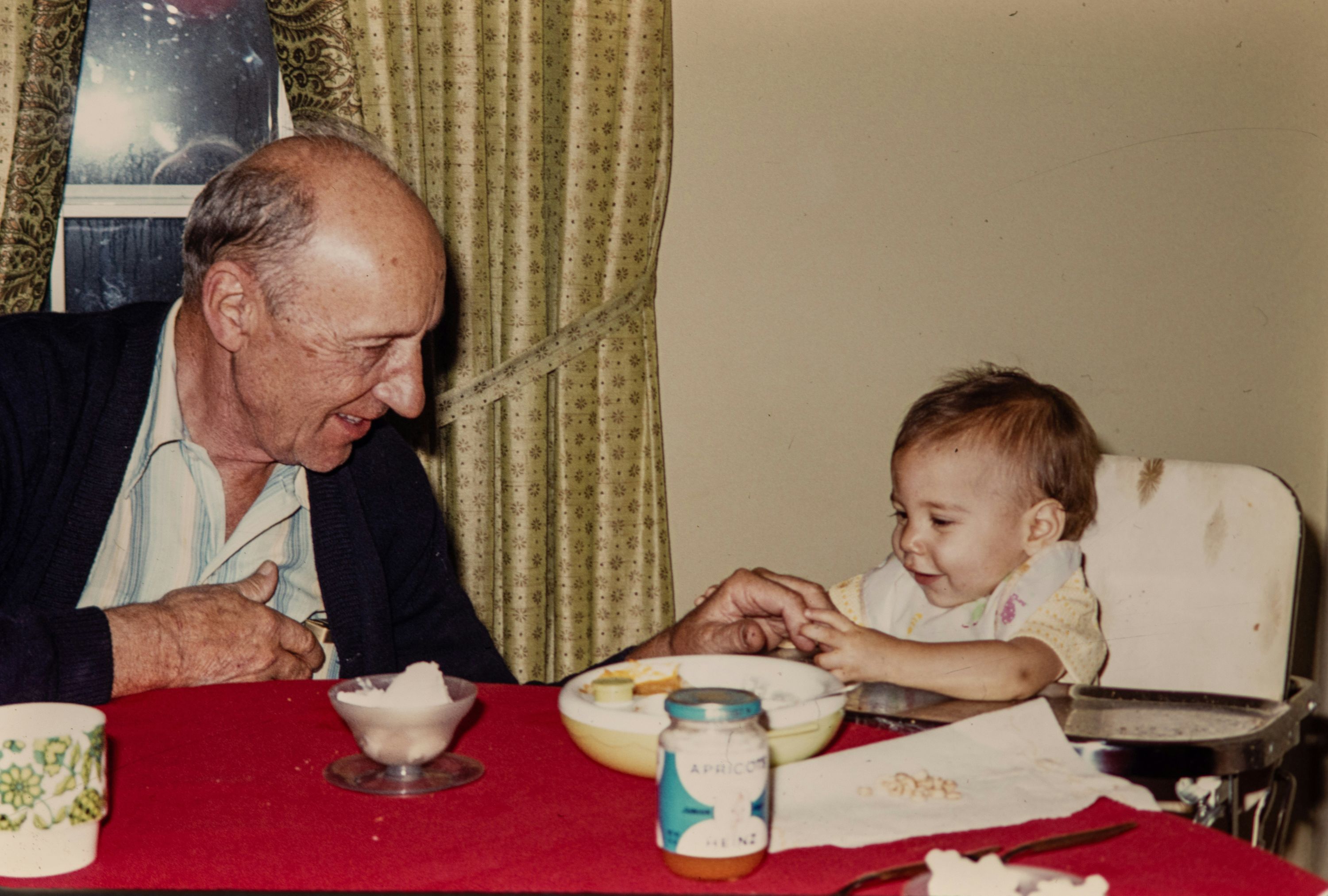 A grandparent and child sitting at the dining table sharing a quiet moment.