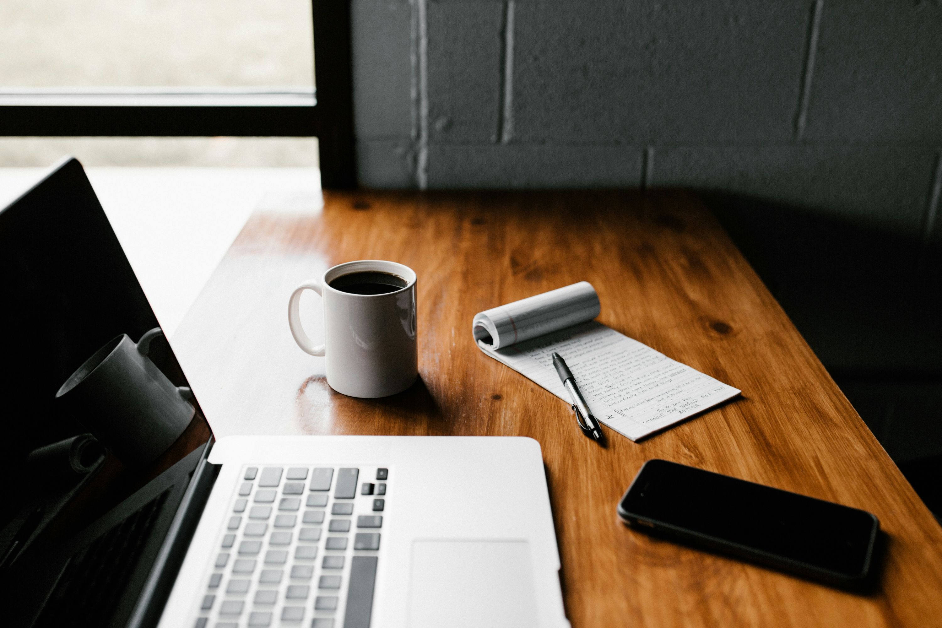 A laptop and an iPhone on a desk during a deliberate, unhurried data migration.