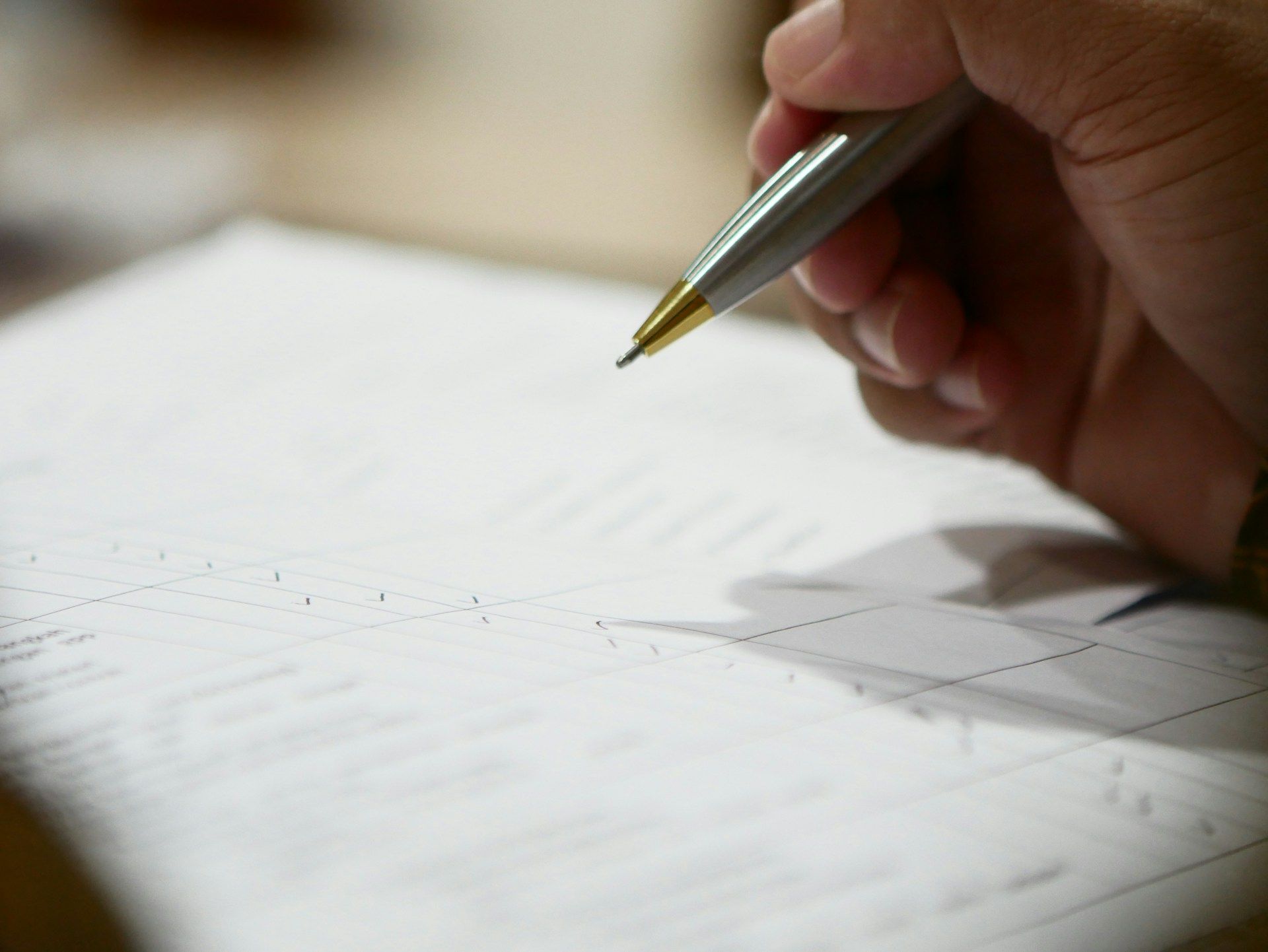A hand signing a legal document with a pen.